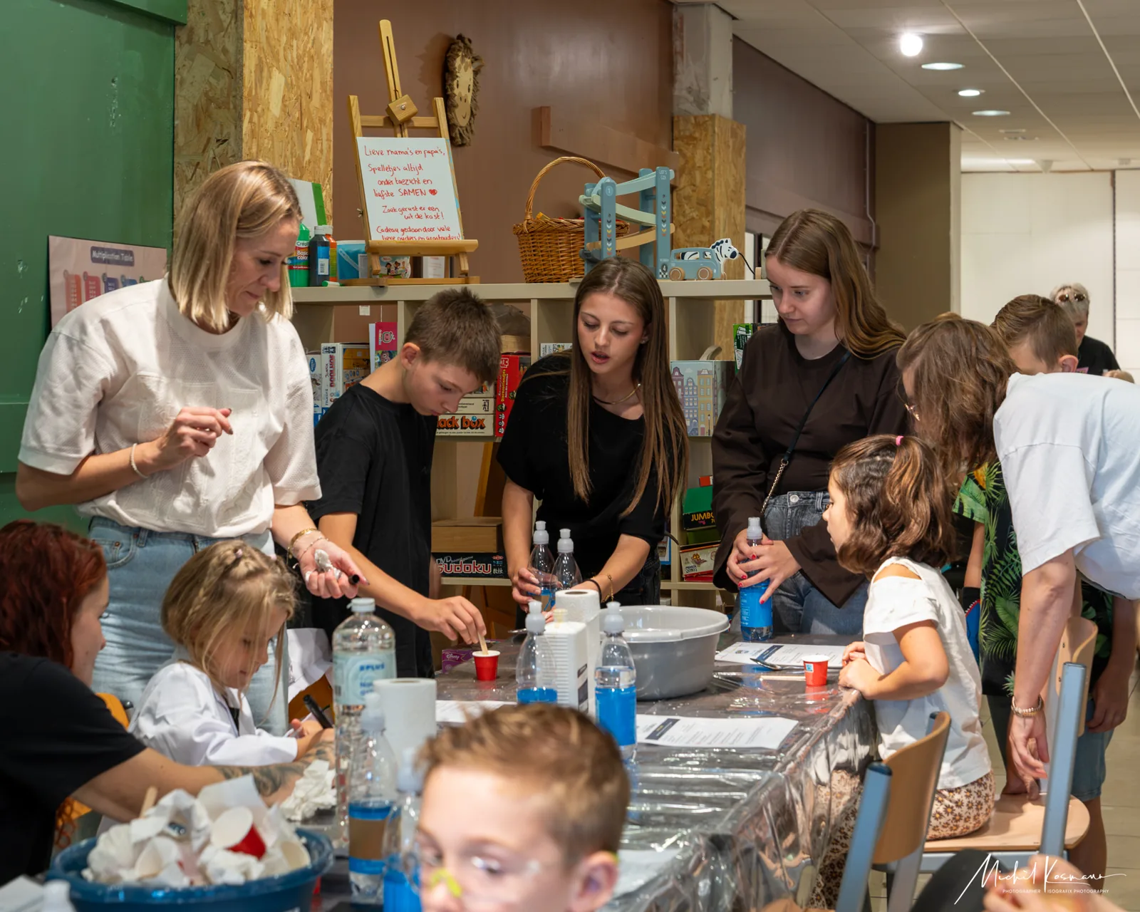 Begeleiders en kinderen voeren samen proefjes uit