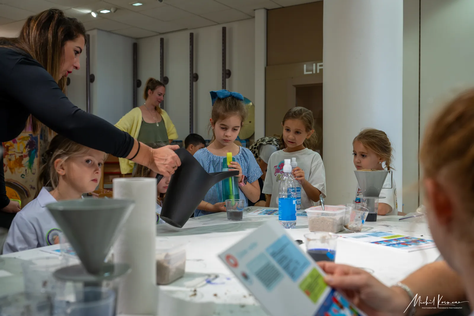 Kinderen doen samen waterproefjes aan een tafel